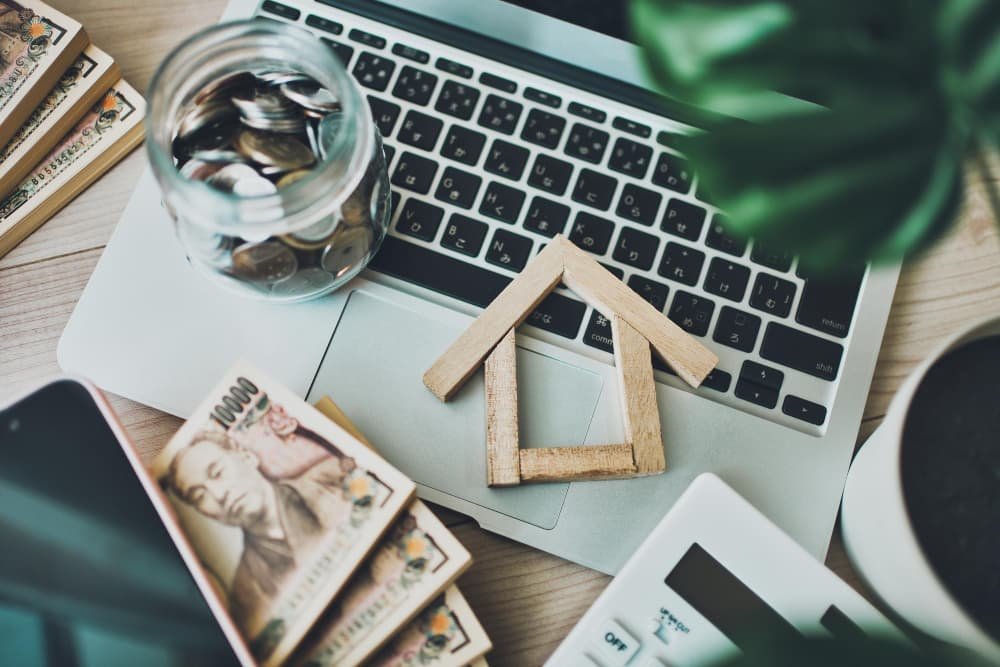 Modèle de maison miniature et ordinateur portable