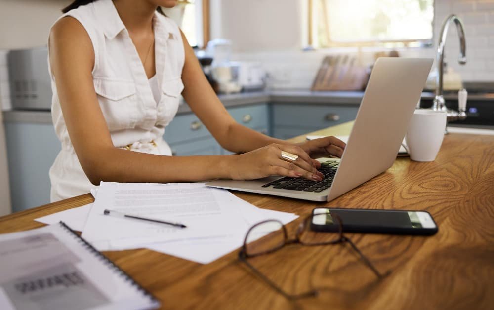 Une femme fait un devis sur son ordinateur portable