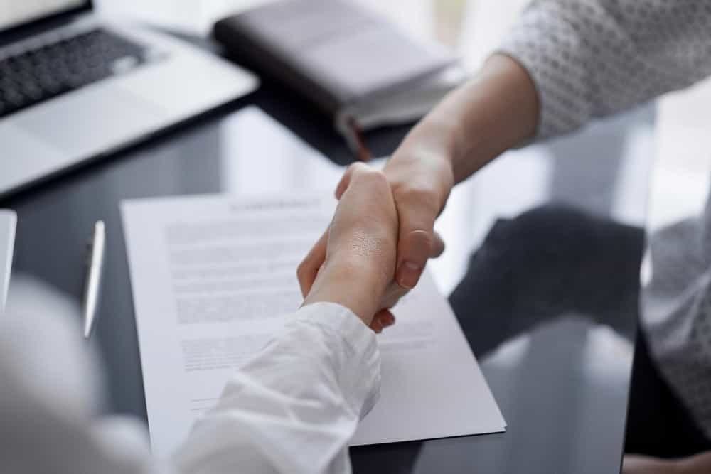 Des gens signant des documents contractuels