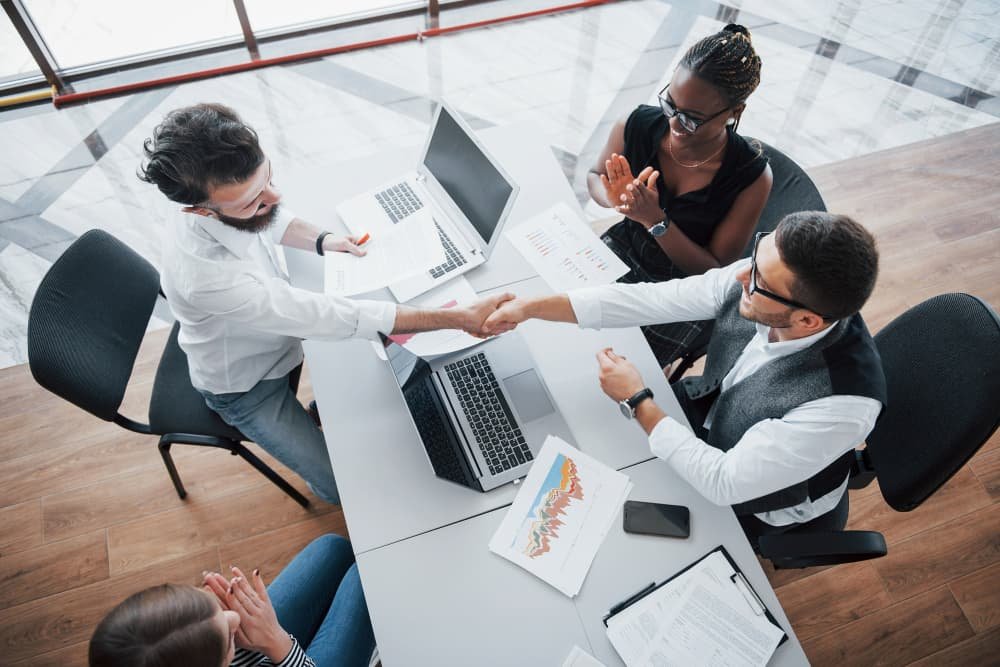 Jeunes employés assis dans le bureau à la table