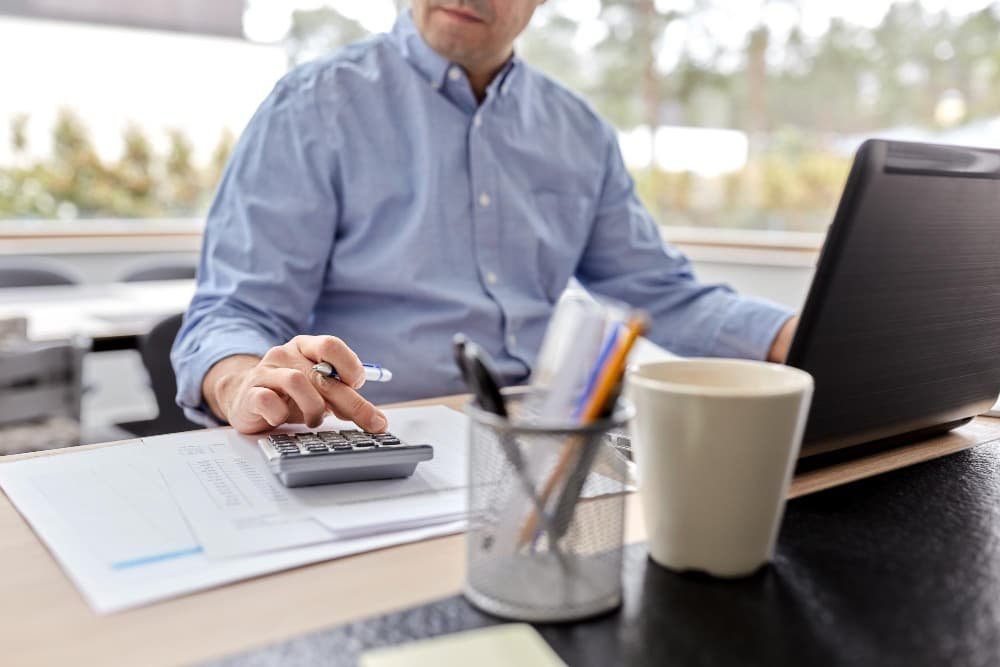 Un homme avec une calculatrice et des papiers Un homme avec une calculatrice et des papiers